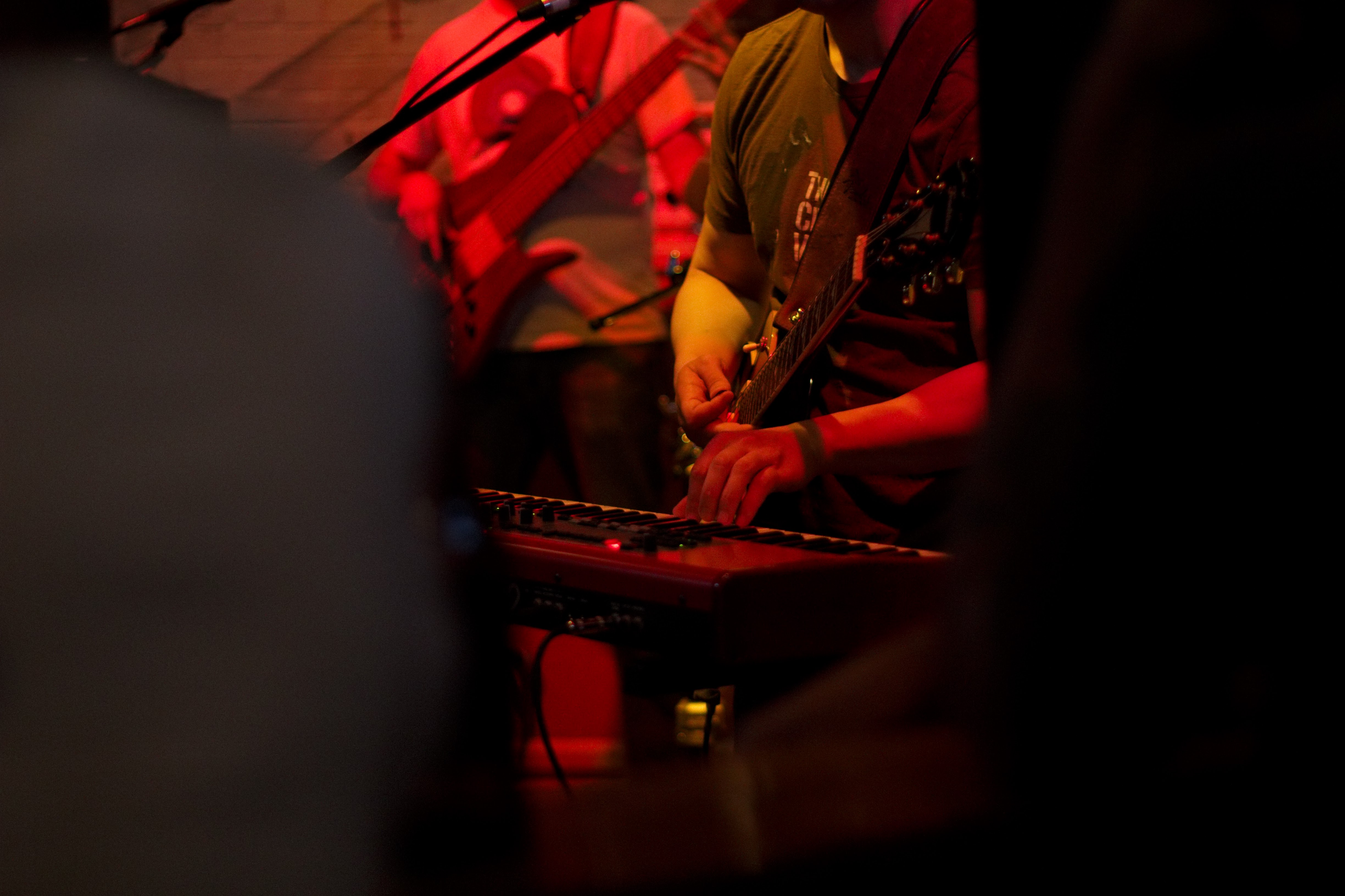 A musician performing under red stage lighting